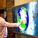 SOSX man using touchscreen to rotate sphere on system